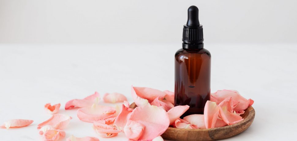 essence-bottle-put-on-wooden-plate-near-rose-petals-4041386